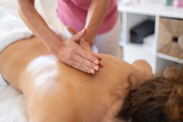 Crop professional masseuse doing massage with hands clasped