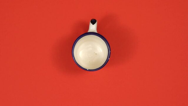Different retro coffee cups rotating on red background. Top view, 4K stop motion animation.