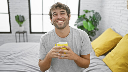 Relaxed morning vibe with a blond, handsome young man, sporting a beard, happily sitting on a cozy...