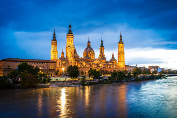 Evening landscape of the Cathedral Basilica of Our Lady of the Pillar on the banks of river Ebro in Zaragoza, Aragon, Spain with vignetting effect - obrazy, fototapety, plakaty