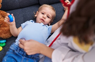 Mother and son doctor examining child at home