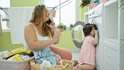 Mother and daughter bonding over household chores, a heartwarming conversation on a smartphone in...