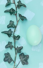 Easter decoration with colored eggs and ivy on abstract background