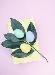 Easter decoration with colored eggs and green leaves 