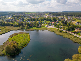 Aerial view of the winding river and blooming fields. The river flows along agricultural fields and forests. Flying a drone over fields, forests and rivers. Natural landscape.