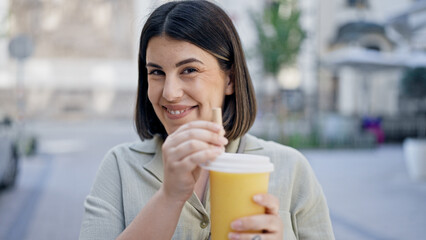 Young beautiful hispanic woman drinking bubble tea in the streets of Vienna