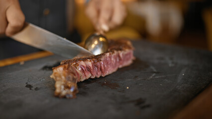 Young man carving meat at the restaurant