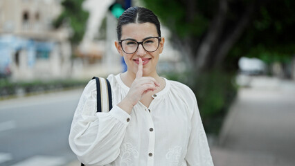 Young beautiful hispanic woman woman smiling asking for silence at street