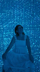 Fotobehang Smiling beautiful hispanic woman experiencing immersive futuristic exhibit at modern museum - lasers, lights, innovation at their best! © Krakenimages.com