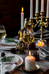 Beautiful table setting for family Christmas dinner at home. Cozy atmosphere, candlelight. Wine...