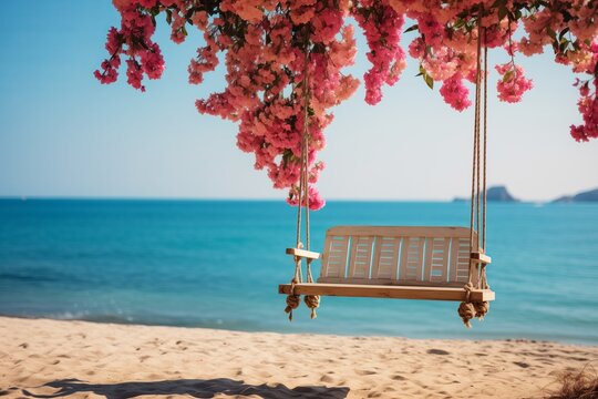 Wooden swing on the beach with blooming bougainvillea flowers