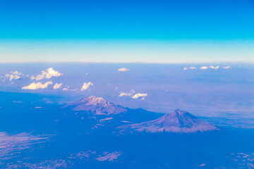Flying airplane over Mexico Clouds Sky Volcanoes Mountains City desert.