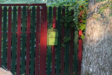 Colourful village gate with postbox