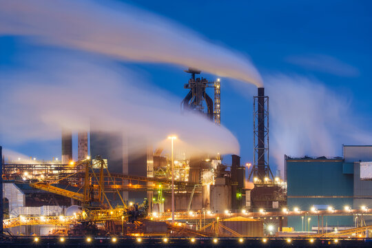 Oil refining. Heavy industry. View of production and factory. View of the factory at night. Emission of harmful substances into the atmosphere. Photo for background, advertising and wallpaper.