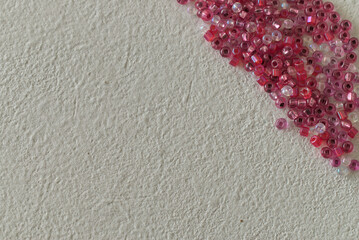 overhead view and macro closeup of pink glass beads on a white surface