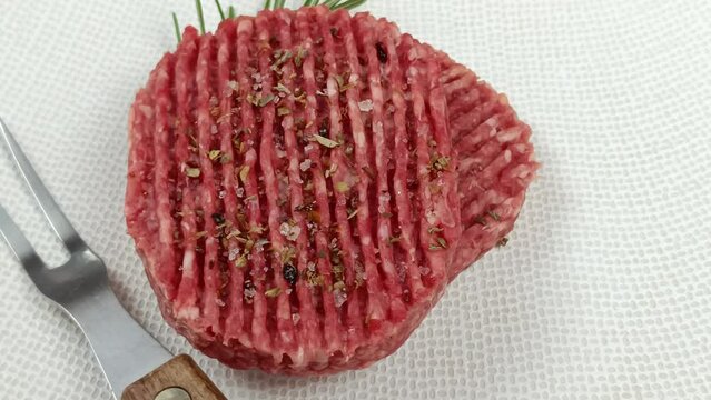 steak hach&eacute; de boeuf cru, en gros plan, dans une assiette