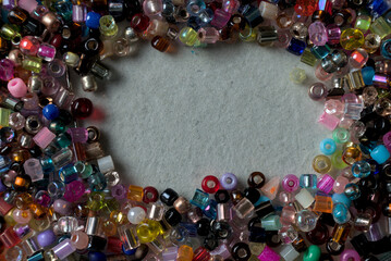 overhead view and macro closeup of multicolored glass beads on a white surface