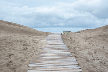 Camino de madera en la arena hacia el mar