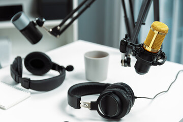 Modern office studio equipment microphone setting, laptop, tablet and headphone prepared with...