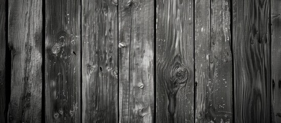 A black and white photograph showcasing a weathered wooden wall, with vintage charm and rustic appeal. The old grey wood planks create a nostalgic ambiance that defines the essence of the image. - obrazy, fototapety, plakaty