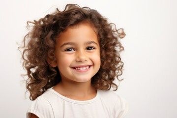 Portrait of a smiling little girl with curly hair on a white background