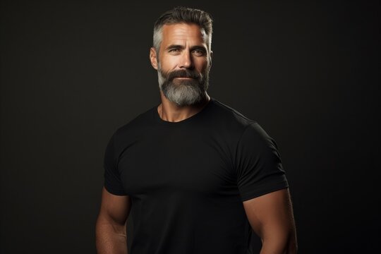 Handsome bearded man in black t-shirt on dark background
