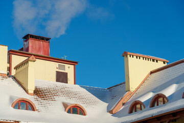 Snow and ice on the roofs of buildings. Icicles hang from the roofs of houses. The probability of...