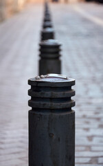A street scene capturing a row of bollards