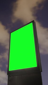 Timelapse, vertical video: blank vertical street green billboard poster or advertising pillar against the dark sky with stars and clouds at night. Green screen, chroma key and time lapse concept