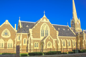 Side facade of Victorian Gothic Reformed Mother Church in Graaff-Reinet, Eastern Cape, Great Karoo, South Africa. Historical Dutch church, built 1886, in the city center. Sunny day with blue sky