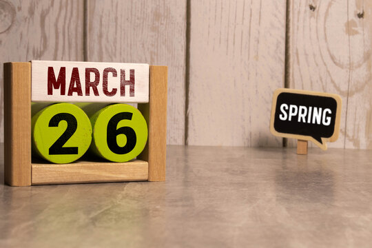 March 26th. Image of march 26 wooden color calendar on blue background. Spring day, empty space for text.