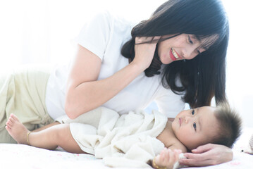 Obraz na płótnie Canvas Mom play with baby in a bedroom