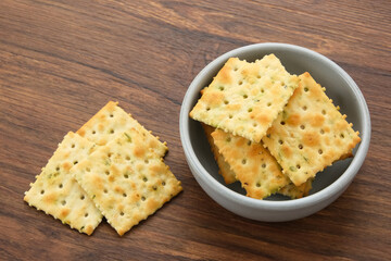 Stacked square biscuits, with a sprinkling of dry vegetables, savory and crunchy
