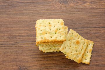 Stacked square biscuits, with a sprinkling of dry vegetables, savory and crunchy
