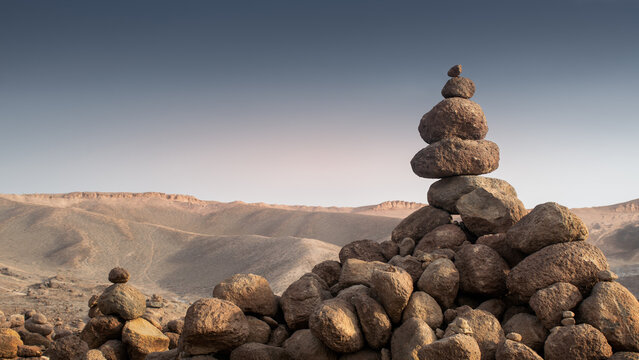 Desert apachetas in a dry landscape at sunset