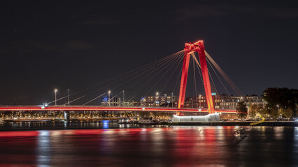 Fototapeta na wymiar Die Willemsbrug ist eine rote Schrägseilbrücke über die Nieuwe Maas in Rotterdam bei Nacht.
