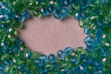 faceted glass beads in blue and green tones on a white surface