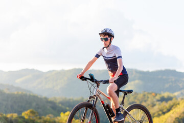 Brazilian cyclist riding his bike in the mountains. He's wearing Cycling Clothing and exercising on an outdoor trail	
