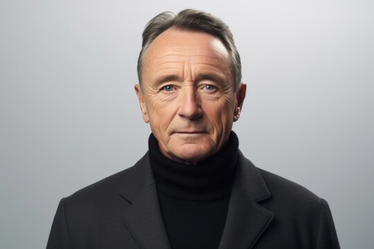 Portrait of a mature man in a black coat looking at the camera.