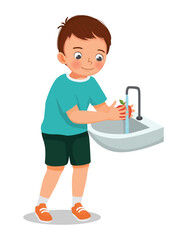 Cute little boy washing apple fruit at the sink
