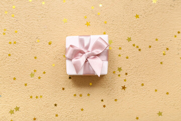 Gift box and confetti on brown background. International Women's Day