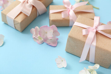 Composition with cute gift boxes and flowers on cyan background