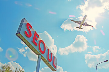 Plane landing in Seoul, South Korea, with "SEOUL" road sign in frame	