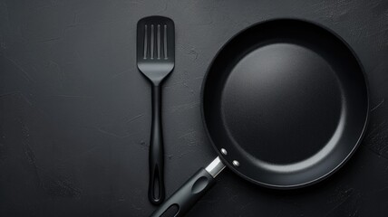 Frying pan and spatula on a dark textured surface