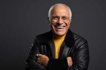 Portrait of a smiling senior man in black leather jacket and eyeglasses.