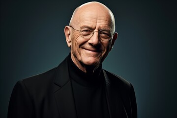 Portrait of a smiling senior man in a black suit and glasses.