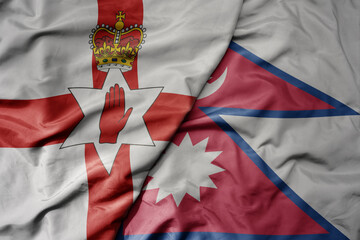 big waving national colorful flag of nepal and national flag of northern ireland .