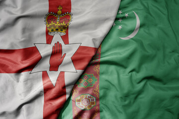 big waving national colorful flag of turkmenistan and national flag of northern ireland .
