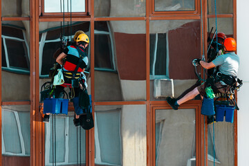 Men at work cleaning exterior windows of building