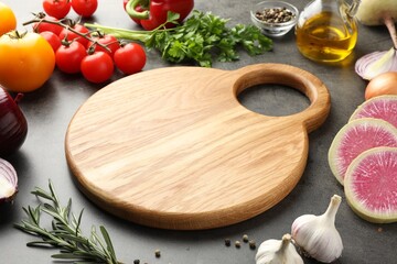 Wooden cutting board and products on dark table